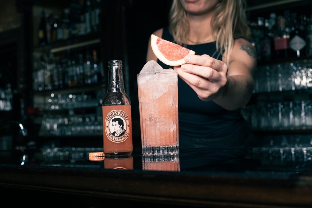 Pink Paloma im Highballglas. Rezeptbild mit Thomas Henry Pink Grapefruit und Grapefruitachtel